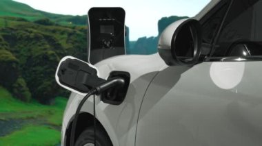Elektro jeneratör sürücüsüyle enerji sürdürülebilir araba gücü, şarj istasyonunda şarj edilen batarya, ilerici seyahat konsepti için dağ zeminine sahip. Temiz ortamın sembolü olarak doğadaki EV otomobil.