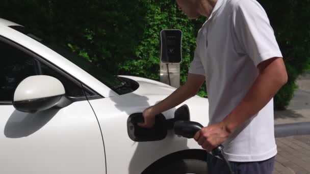 Postępowy Człowiek Instaluje Wtyczkę Kablową Swojego Pojazdu Elektrycznego Samochód Stacji — Wideo stockowe
