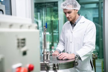 Bir bilim adamının portresi, eczacı laboratuarda bilimsel ekipman kullanarak kenevir yağı çıkarıyor. Alternatif tıbbi tedavi için esrar çıkarma kavramı