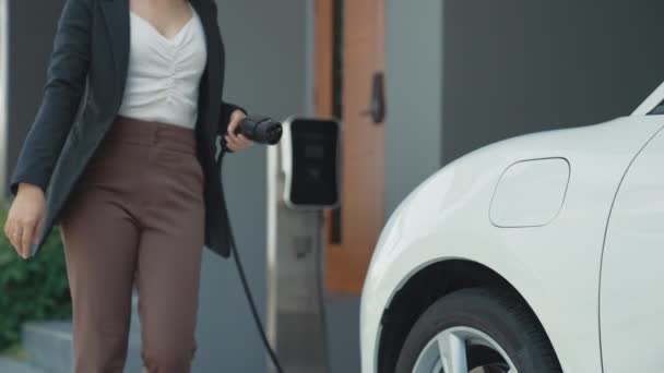 Прогрессивная Женщина Устанавливает Зарядную Станцию Подключаемую Электрическому Автомобилю Дома Автомобили — стоковое видео