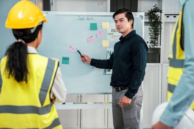 A team of investor and competent engineers brainstorming on the whiteboard to find new ideas and making plans. The idea of a team gather ideas together.