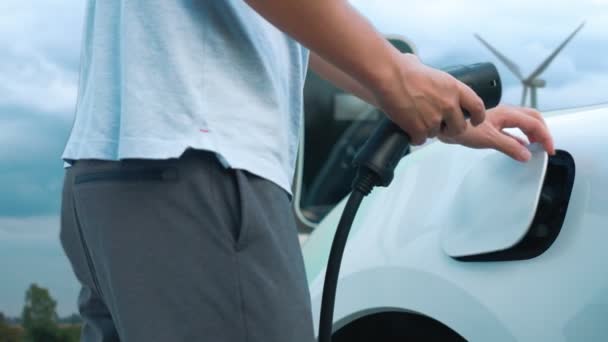 Прогрессивный Человек Заряжает Свой Автомобиль Зарядной Станции Питаемой Чистой Энергии — стоковое видео