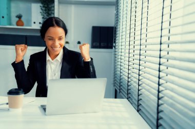This photo depicts a young African American and competent woman at her workplace. A female employee in her office at work.