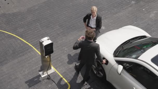 Progressive Geschäftsfrau Und Geschäftsfrau Lehnt Einem Elektroauto Das Eine Ladestation — Stockvideo