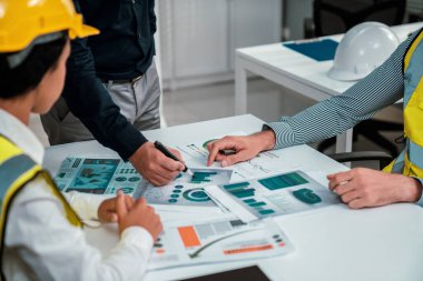 Engineers and competent employer discussing plans and blueprints together with tablet in the office. Concept of team contribution of ideas for engineering project.