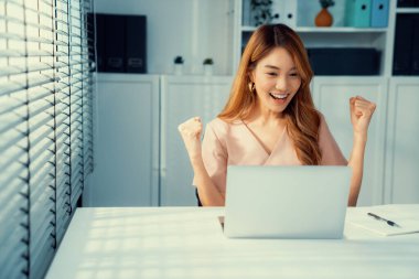 A young female employee receives a promotion, good news or finished her task and overjoyed for being a competent worker.