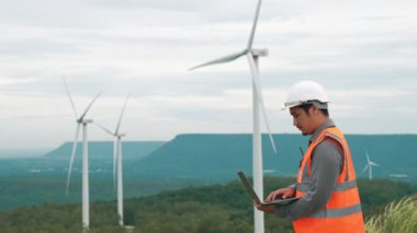 Kırsal kesimdeki bir tepenin tepesinde ya da dağda rüzgar çiftliğinde çalışan bir mühendis. Yenilenebilir ve sürdürülebilir enerjinin gelecekteki üretimi için yenilikçi bir ideal. Rüzgar türbininden enerji üretimi.
