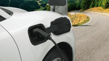Tepe yolundaki şarj istasyonunda elektrikli arabanın çevresel farkındalığı için yenilikçi bir kavram. EV araba temiz çevre için yenilenebilir enerjiden güç alıyor.