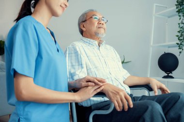 Caring nurse and a contented senior man in a wheel chair at home, nursing house. Medical for elderly patient, home care for pensioners.