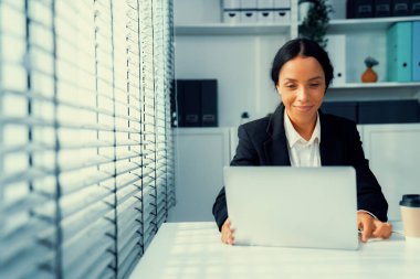 This photo depicts a young African American and competent woman at her workplace. A female employee in her office at work.