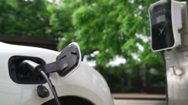 Yakın çekim yenilikçi modern ulaşım konsepti, elektrikli araba şarj istasyonunda gökyüzünden yansıyan yüksek detay ile şarj ediliyor. Yenilenebilir enerji tarafından kullanılan çevre dostu elektrikli araç.