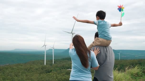 渐进式快乐家庭的概念 享受他们在风力涡轮机农场的时光 风力发电机组由风力发电机组组成 风力发电机组在农村一侧 丘陵地带在地平线上 — 图库视频影像