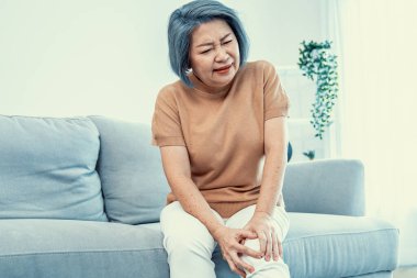 An agonizing elderly woman is experiencing chest pain. Medical attention, medical service for seniors.