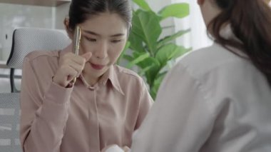 Ofis çalışma alanında birlikte çalışan iki genç hevesli iş kadını. Genç meslektaşlar tartışırken ve dizüstü bilgisayar kullanırken. Modern ofis çalışanları masada birlikte oturuyorlar..