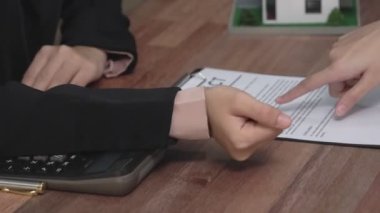 Gayretli emlak acentesi müşteriye bir emlak acentesi tarafından tavsiye edilirken, ev kredisi için müşteri sözleşmesi belgelerini sunar..