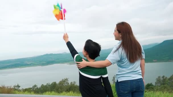 진보적 의아들 장난감 풍차를 호수의 아름다움을 즐기며 휴가를 보내고 — 비디오