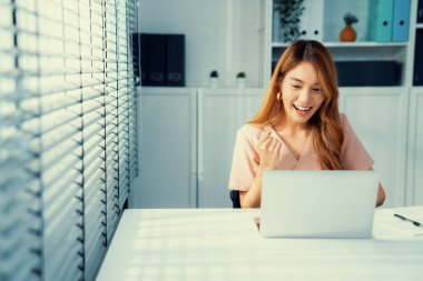 A young female employee receives a promotion, good news or finished her task and overjoyed for being a competent worker.