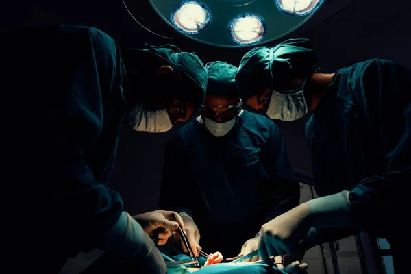 手術チームは滅菌手術室で患者に手術を行います ランプに照らされた手術室では 専門家と自信のある外科チームが無意識の患者に医療を提供します — ストック写真