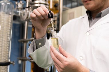 Bir bilim adamı ya da eczacı CBD kenevir yağını laboratuarda tıbbi amaçlar için çıkartıyor. Esrar çıkarma makinesinden üretilen alternatif esrar temelli ilaçlar.