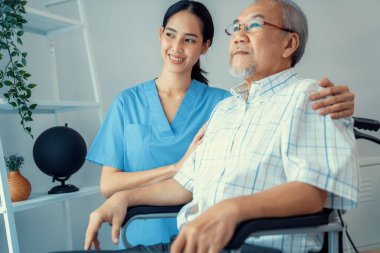 Caring nurse and a contented senior man in a wheel chair at home, nursing house. Medical for elderly patient, home care for pensioners.