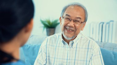 A young female doctor inquires about personal information of a contented senior at home. Medical care for the elderly, elderly illness, and nursing homes, home care.