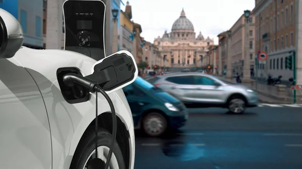 Progressive electric car recharging battery at the charging station in Vatican, historical christian church, city center. EV car connected with charging point via cable power plug.
