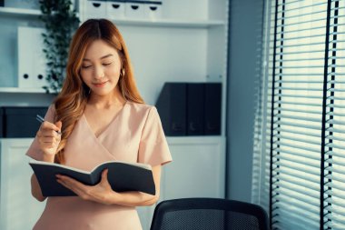 Young competent office lady, intern, secretary holding a log in office room. Concept of various career for office working. Concept of diverse office careers.