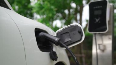 Elektrikli araba parkı ve şarj istasyonunun yanında şarj edilen enerji konseptinin sürdürülebilirliği. Çevresel koruma için yenilenebilir enerji tarafından kullanılan elektrikli araç.
