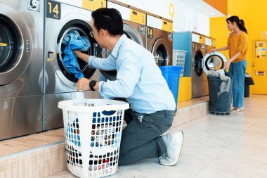 Asyalılar çamaşırlarını yıkamak için halka açık alanda kaliteli para makinelerini kullanıyorlar. Kamu dairesinde ticari çamaşır ve kurutma makinesi kavramı.