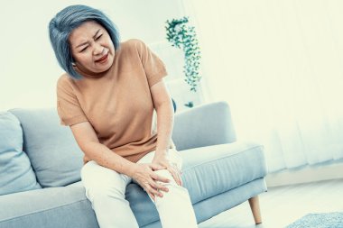 An agonizing elderly woman is experiencing chest pain. Medical attention, medical service for seniors.