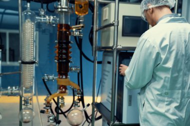 Bilim adamı ya da eczacı tıbbi ve sağlık hizmetleri için kenevir yağı çıkarıyor. Esrar ürünlerinden alınan sağlık hizmetleri eczanesi. Cam tüpler ve teçhizatlı kenevir yağı çıkarma makinesi.