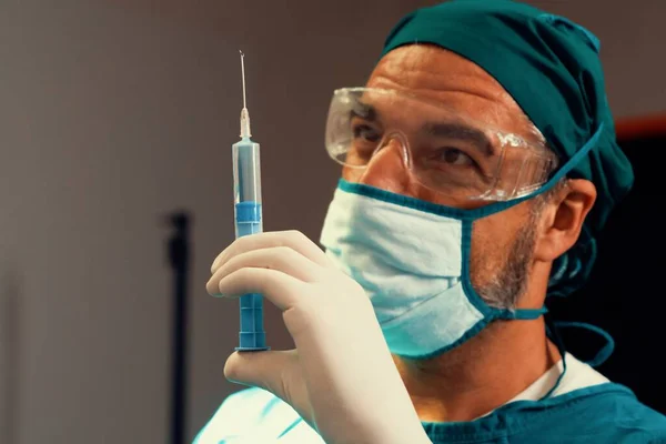 의사는 에서의 수술을 술병에서 주사기를 채우고 수술용 주사를 — 스톡 사진