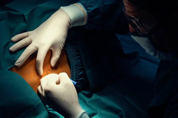 外科医は 現代の外科機器と滅菌手術室で手術を行う前に 患者に注射器で麻酔を注入します 専門家と自信のある外科医による医療手術 — ストック写真