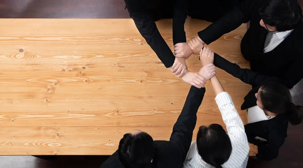 stock image Top view cohesive group of business people join hands stack together, form circle over meeting table for copyspace. Colleagues working to promote harmony and synergy team building concept in workplace