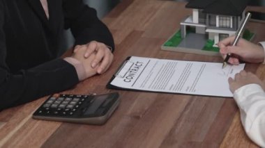 İş kadını ofiste başarılı bir iş anlaşması yaptıktan sonra sözleşme imzaladı. Hevesli müşteri el yazısı resmi kredi, gayrimenkul veya yatırım sözleşmesi belgesine imza atıyor.