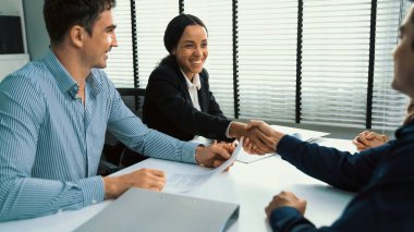 Commercial contract signed by competent people of various ethnicities and shake hands. Trade agreements, two-party business transactions.