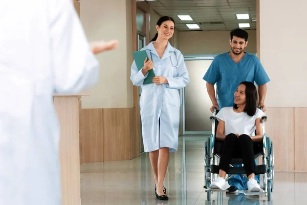 Lekarz Pielęgniarz Przewożą Pacjentkę Wózku Inwalidzkim Sterylnym Szpitalnym Korytarzem Opieka — Zdjęcie stockowe
