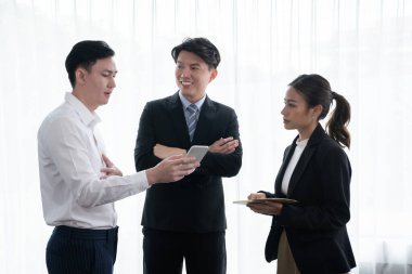 Mentor, manager advice younger colleagues in workplace. Businesspeople discussing or planning financial project strategy, talking together for harmony and strong teamwork in office concept.