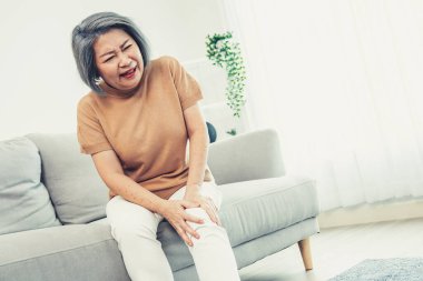 An agonizing elderly woman is experiencing chest pain. Medical attention, medical service for seniors.