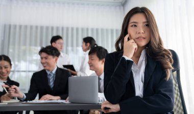 Focus portrait of female manger, businesswoman in the harmony meeting room with blurred of colleagues working together, analyzing financial paper report and dashboard data in background.