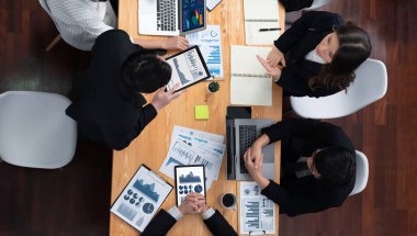 Top-view business team of financial data analysis meeting with business intelligence, report paper and dashboard on laptop for marketing strategy. Business people working together in office of harmony