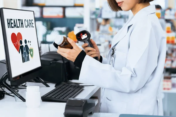 stock image Closeup young pharmacist scanning the barcode of a mockup qualified pharmaceutical, medicine pill container or bottle for copyspace at pharmacy.