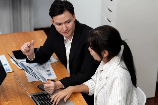 stock image Harmony in office concept as business people analyzing dashboard paper together in workplace. Young colleagues give ideas at manager desk for discussion or strategy planning about project.