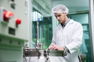 Bir bilim adamının portresi, eczacı laboratuarda bilimsel ekipman kullanarak kenevir yağı çıkarıyor. Alternatif tıbbi tedavi için esrar çıkarma kavramı