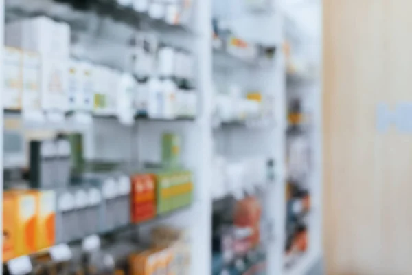 Pharmacy blurred abstract background qualified drug, medicinal product on shelf background. Blurry light tone wallpaper of drugstores interior medications displayed on shelves for healthcare concept.