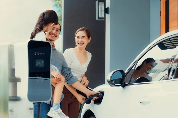 Progressive Young Parents Daughter Electric Vehicle Home Charging Station Green — Stockfoto