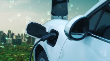 Gelişmiş yeşil şehir ESG sembolü elektrikli araçla arka plan, EV araba şarj noktasındaki enerji yenilenebilir enerji taşımacılığıyla çevre bilincini artırmak için şarj ediliyor.