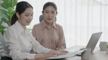 Hevesli ofis çalışanları ofis işyerindeki başarılarını kutluyorlar. Bilgisayarlı bir masada iş birliği yapan ve başarı elde eden meslektaşlar. İki iş kadını işlerinden memnun..