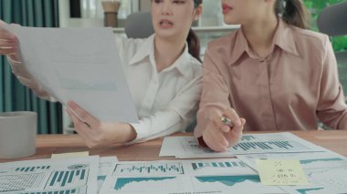 Ofis çalışma alanında birlikte çalışan iki genç hevesli iş kadını. Genç meslektaşlar tartışırken ve dizüstü bilgisayar kullanırken. Modern ofis çalışanları masada birlikte oturuyorlar..