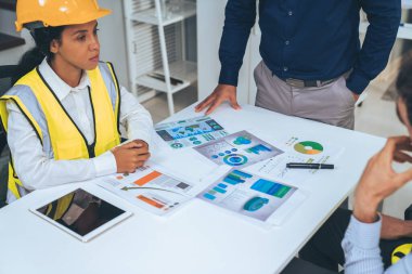 Engineers and competent employer discussing plans and blueprints together with tablet in the office. Concept of team contribution of ideas for engineering project.